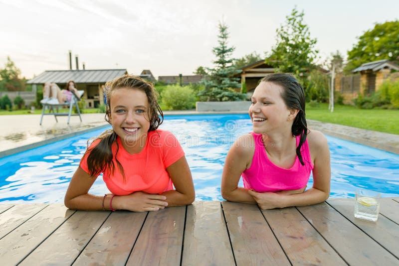 Two Young Teenage Girls Having Fun In The Swimming Pool Stock Image