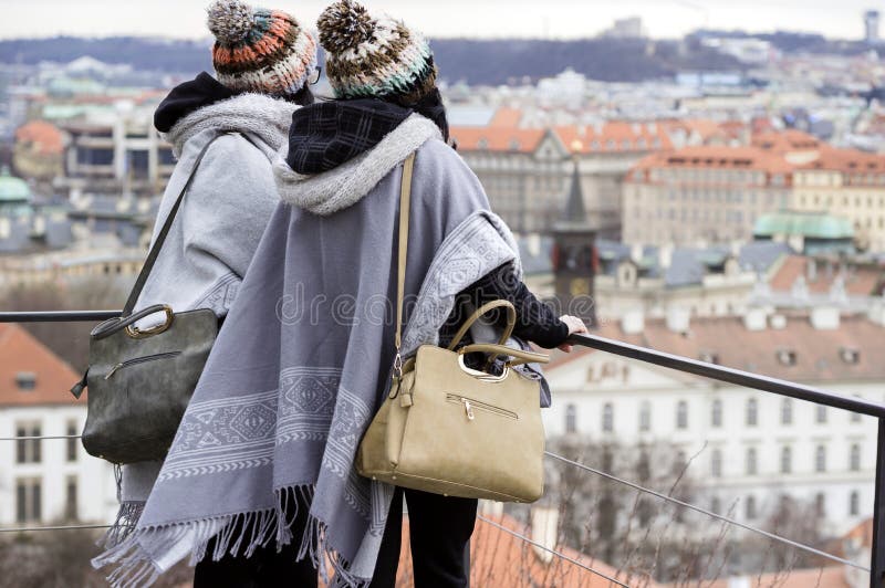 Dos joven irreconocible mujer mirar sobre el Praga la ciudad más alto.