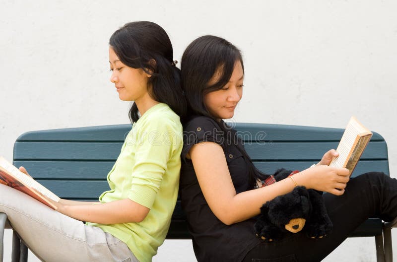 Two young woman enjoy reading