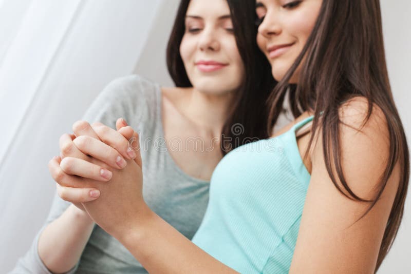 Lesbian Couple In Bedroom At Home Sitting One Girl Doing Massage To Another Smiling Playful