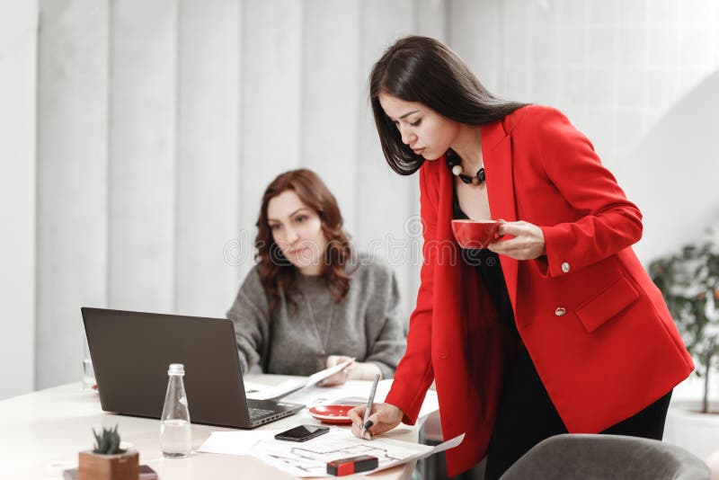 Two young women designer are working at the design project of interior at the desk with laptop and documentation in the stock images Two young women designer are working at the design project of interior at the desk with laptop and documentation in the stock images