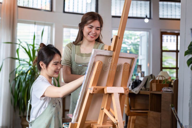 Young Women Enjoying Creative Time Together Drawing Pictures in a Bright Modern Studio stock photos