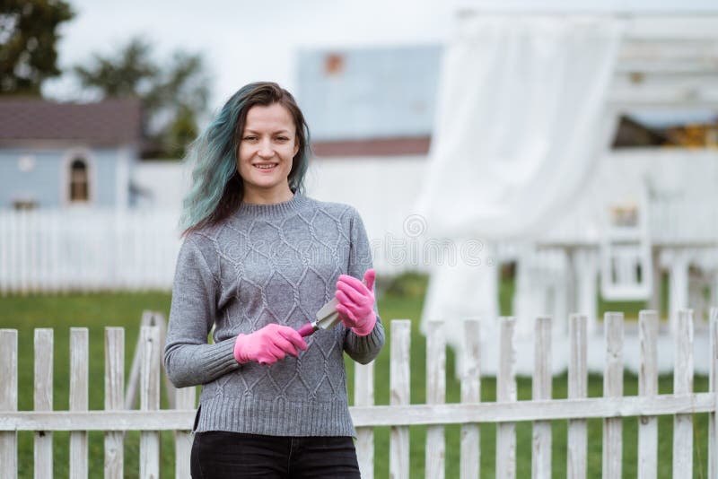 Young women in the background of a garden with gloves and tools with a field of beds royalty free stock image Young women in the background of a garden with gloves and tools with a field of beds royalty free stock image