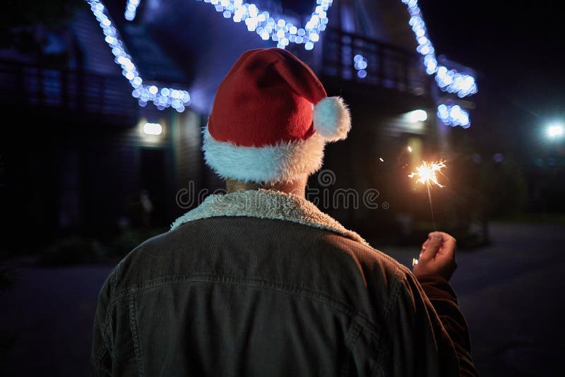 Tylni widok przyjemny mężczyzna trzyma sparkler zdjęcia stock Tylni widok przyjemny mężczyzna trzyma sparkler zdjęcia stock
