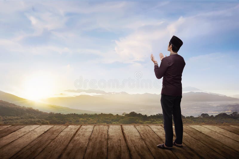 Back view of asian muslim man praying to god with landscape view background. Back view of asian muslim man praying to god with landscape view background