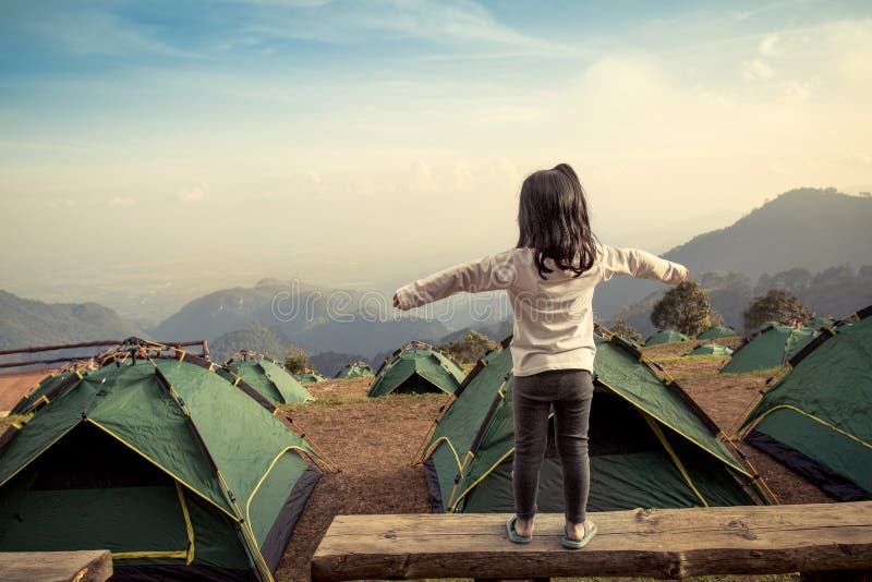 Tylny widok azjatykcia dziewczyna rozszerza jej ręki w campingu