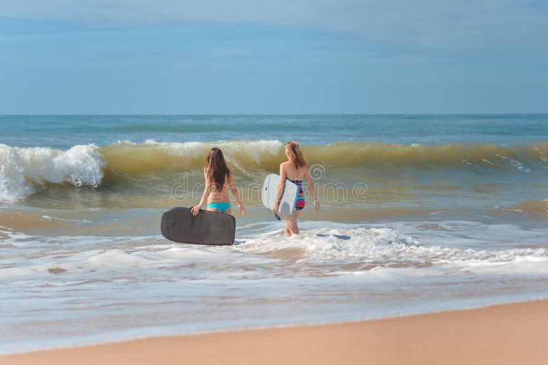 Tylny widok piękne młode kobiety z surfboards fotografia stock Tylny widok piękne młode kobiety z surfboards fotografia stock
