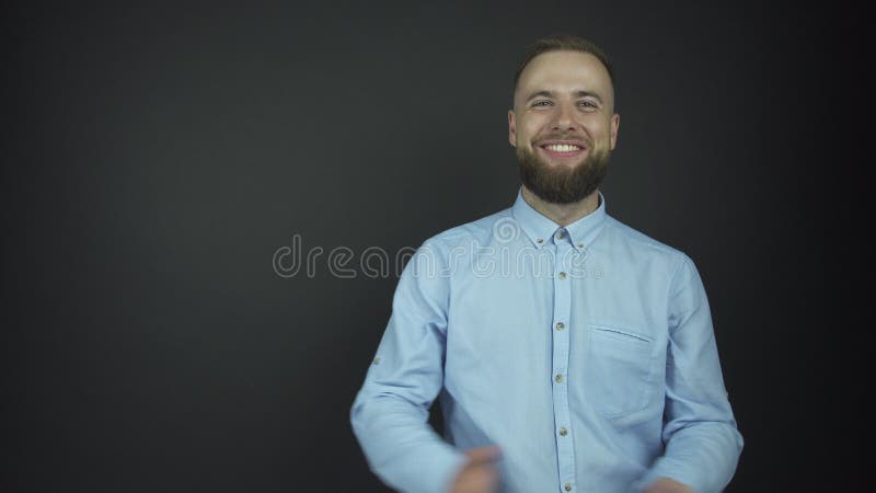 Type barbu belle dans des sourires bleus de chemise gaiement