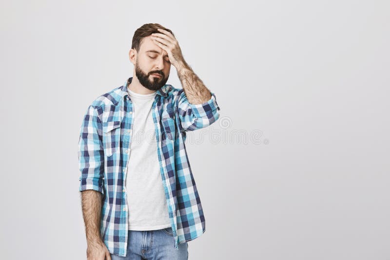 Type barbu malheureux fatigué en test la chemise, tenant la main sur le front, se tenant sur le fond gris homme d'affaires mascul photos stock Type barbu malheureux fatigué en test la chemise, tenant la main sur le front, se tenant sur le fond gris homme d'affaires mascul photos stock