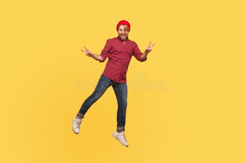 Type branché de hippie joyeux du portrait faisant de la sustentation à regarder la caméra avec le geste de paix de victoire planan images stock