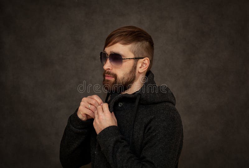 Type brutal de hippie dans des lunettes de soleil, avec une barbe et une coiffure à la mode images stock Type brutal de hippie dans des lunettes de soleil, avec une barbe et une coiffure à la mode images stock