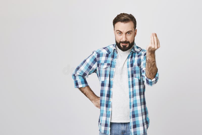 Type caucasien attirant semblant fou et fâché, tenant la main sur la taille tout en montrant obtenez au geste de point avec photographie stock libre de droits Type caucasien attirant semblant fou et fâché, tenant la main sur la taille tout en montrant obtenez au geste de point avec photographie stock libre de droits
