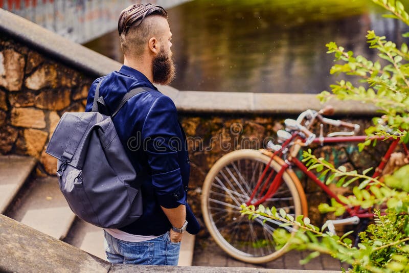 Type moderne avec le sac à dos Vue arrière image stock Type moderne avec le sac à dos Vue arrière image stock