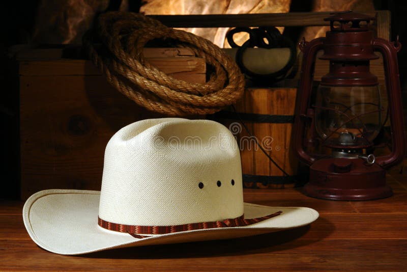 American West rodeo cowboy white straw hat with traditional ranch equipment and old ranching tools in a nostalgic Western barn. American West rodeo cowboy white straw hat with traditional ranch equipment and old ranching tools in a nostalgic Western barn