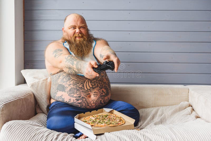 Type épais amusant avec PlayStation à la maison image stock Type épais amusant avec PlayStation à la maison image stock