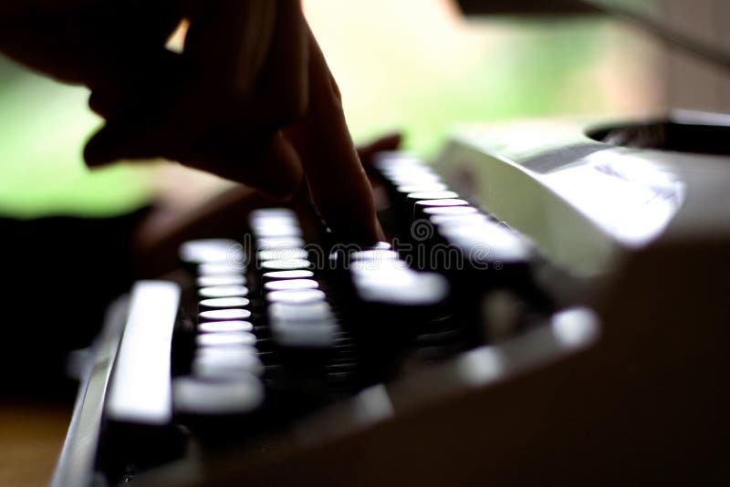 Index finger pressing down on a typewriter key. Index finger pressing down on a typewriter key.