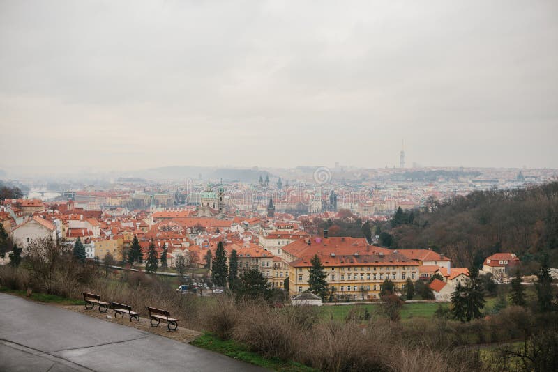 Typical roofs in Prague. Top view - roofs with red tiles in old buildings in Prague. Europe. Empty benches stand in a