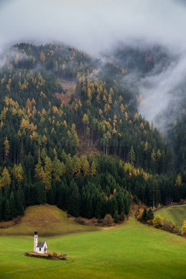 Typical scenery of Trentino Alto Adige South Tyrol in Italy in Dolomites Alps region during autumn with foliage and myst