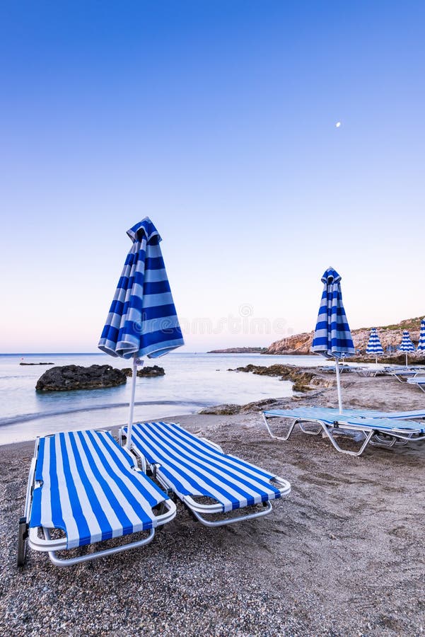 Typical Sun Beds at Pebble Wild Beach in Rhodes, Greece at SUnrise