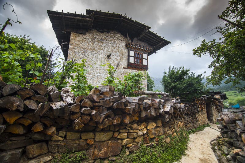 Traditional Bhutanese farmhouse , with firewood on the fence wall , Ura Valley , Bhutan