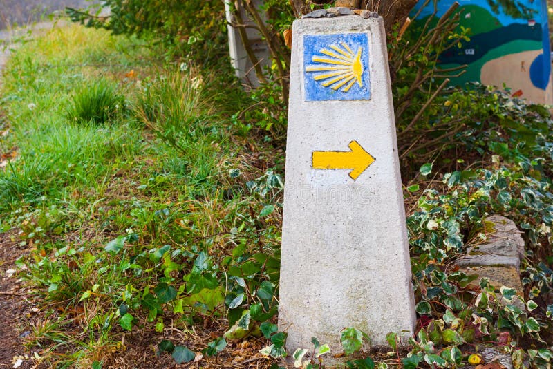 Typical Way of Saint James Camino de Santiago milestone with a yellow shell and yellow arrow stock image