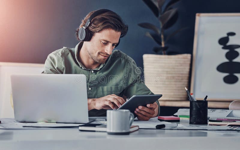 Typing, online and man with tablet, office and laptop for project of video editor and headphones. Intern, morning and stock photo