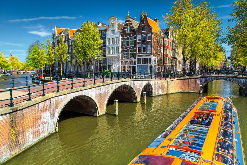 Typische Amsterdam-Kanäle mit Brücken und buntem Boot, die Niederlande, Europa