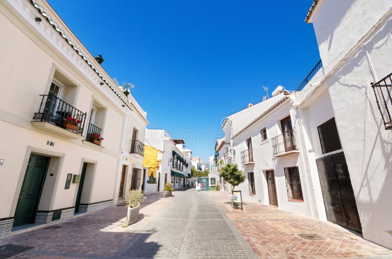 Typische straat met witte huizen in het toeristische dorp van Nerja royalty-vrije stock foto Typische straat met witte huizen in het toeristische dorp van Nerja royalty-vrije stock foto