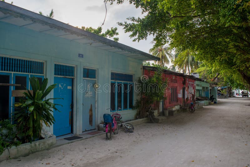 Typisk lokal gata med små hus och träd på den Fenfushi ön fotografering för bildbyråer Typisk lokal gata med små hus och träd på den Fenfushi ön fotografering för bildbyråer
