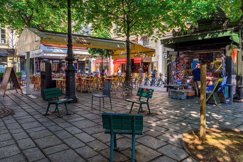 Typisk vy av små kvadrater med kafétabeller i paris france. arkivbild