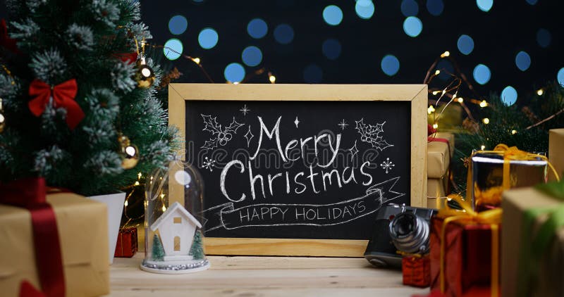 Typografi för glad jul på svart tavla mellan juldekoren