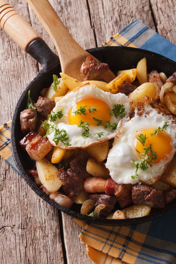 Tyrolean Fried Potatoes with Meat, Bacon and Eggs in a Pan. Vert Stock