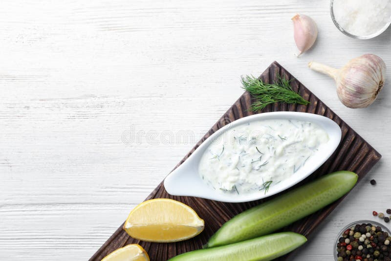 Tzatziki kumberland z cytryną, ogórkiem, koperem i pieprzem na białym drewnianym tle, odgórny widok obraz stock Tzatziki kumberland z cytryną, ogórkiem, koperem i pieprzem na białym drewnianym tle, odgórny widok obraz stock