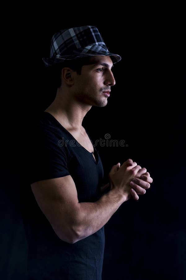 Tânăr cu cămașă neagră purtând pălărie stock photo