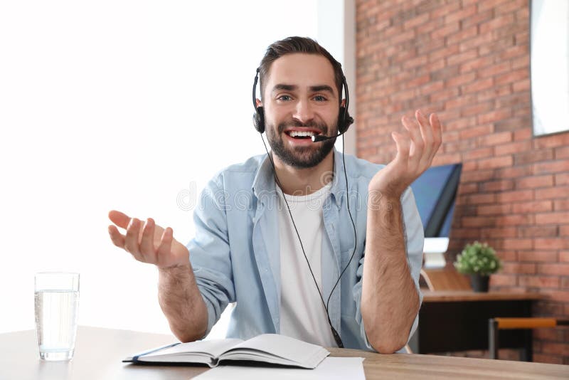 Tânăr cu căști care se uită la cameră și care utilizează chat video royalty free stock photo