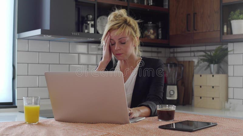 Tânără care are dureri de cap în timp ce lucrează la notebook stock footage