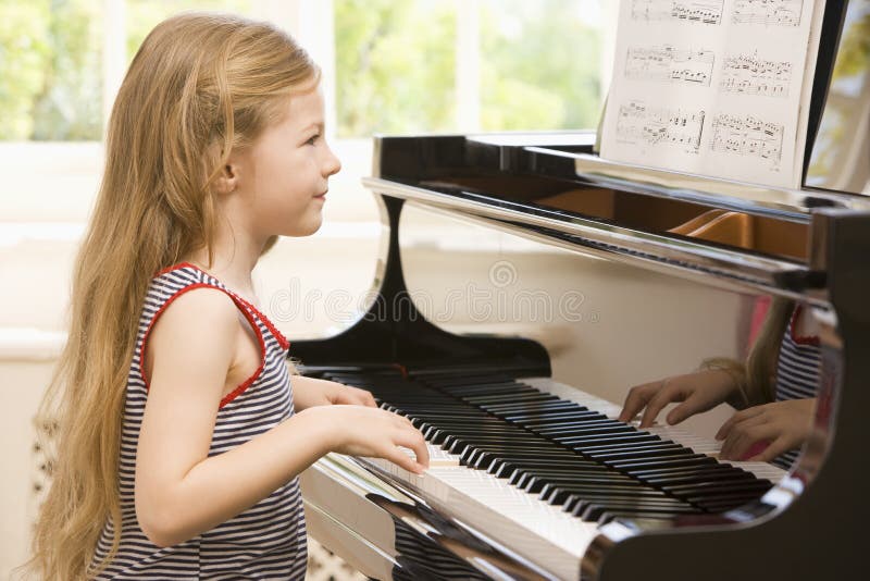 Tânără fată cântând la pian stock photo