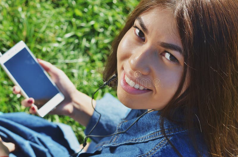 Tânără studentă talentată îmbrăcată în haine obișnuite mergând prin oraș și ascultând postul de radio preferat royalty free stock images