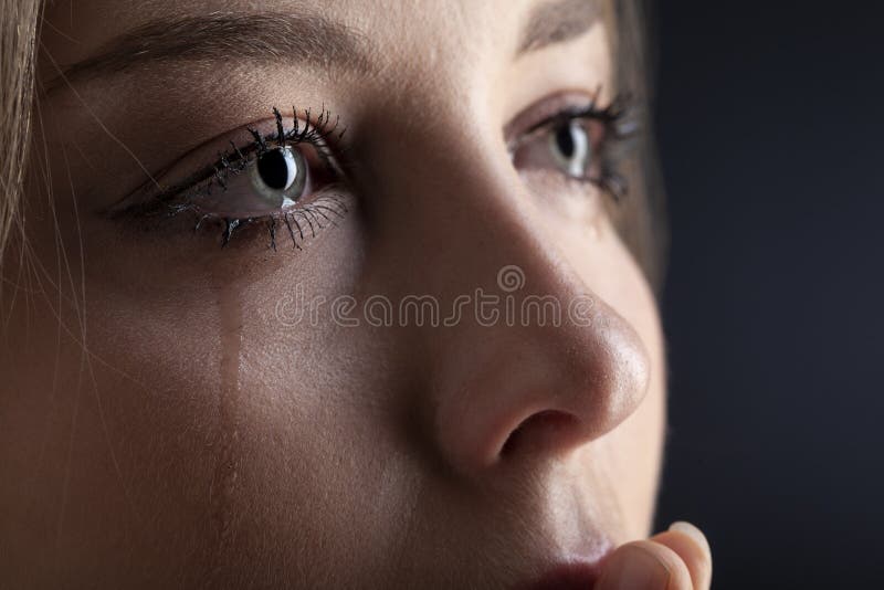 Tårar på kvinnans ansikte, skönhetsskrik på svart bakgrund