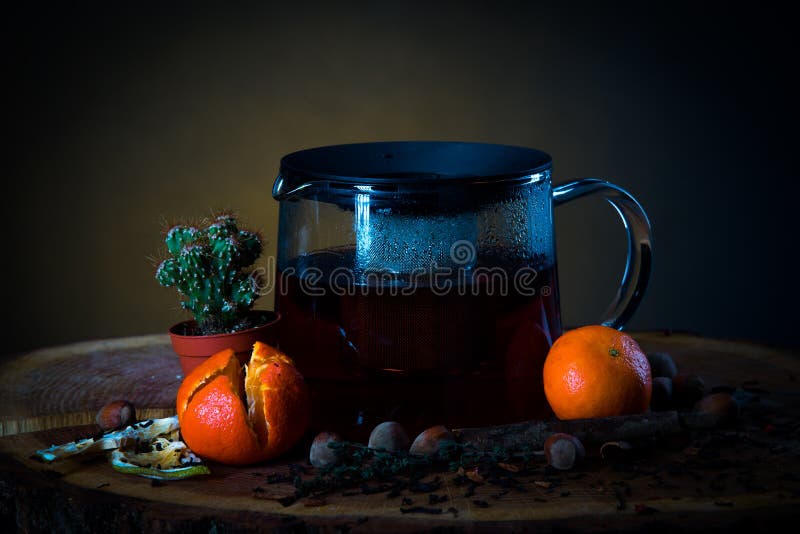 Tè caldo in una teiera su un bordo di legno con i mandarini ed il cactus fotografia stock libera da diritti Tè caldo in una teiera su un bordo di legno con i mandarini ed il cactus fotografia stock libera da diritti