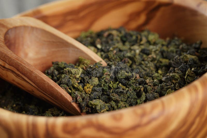 Tè verde di Oolong in ciotola di legno fotografia stock libera da diritti Tè verde di Oolong in ciotola di legno fotografia stock libera da diritti
