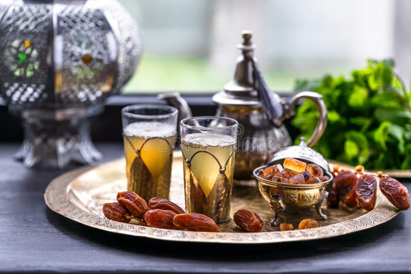 Té de verde menta marroquí en dos vidrios y una tetera con la menta fresca y Sugarcubes imágenes de archivo libres de regalías Té de verde menta marroquí en dos vidrios y una tetera con la menta fresca y Sugarcubes imágenes de archivo libres de regalías