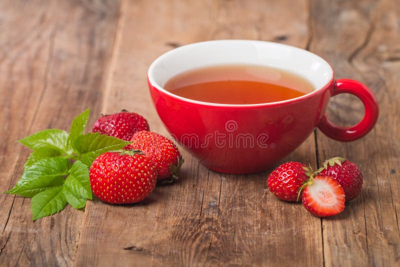 Té del inglés negro en taza roja con la fresa imágenes de archivo libres de regalías Té del inglés negro en taza roja con la fresa imágenes de archivo libres de regalías