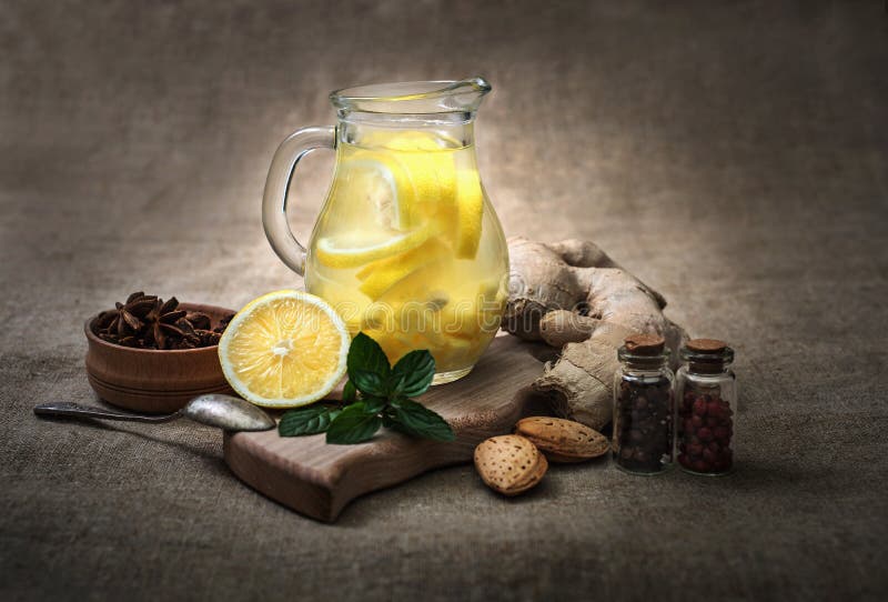 Té del jengibre con el limón, la raíz del jengibre y la menta en fondo rústico imagen de archivo Té del jengibre con el limón, la raíz del jengibre y la menta en fondo rústico imagen de archivo
