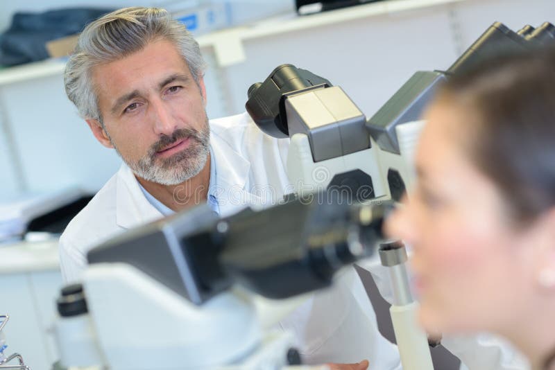 Técnico de laboratório que olha o colega imagem de stock Técnico de laboratório que olha o colega imagem de stock