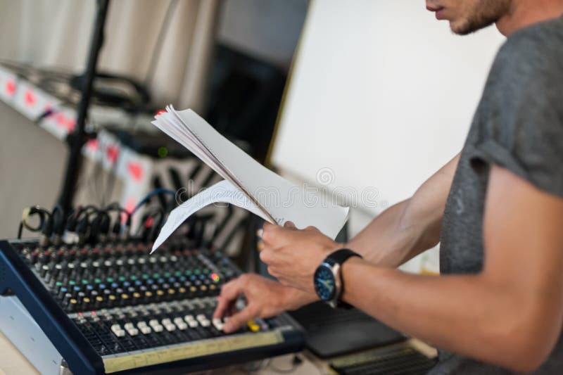 Técnico de sonido en el teatro que ajusta los elementos de los sonidos que consideran la escritura. Detrás de escena. Técnico de sonido que ajusta los elementos de sonido en función del rendimiento de teatro y que parece escrito