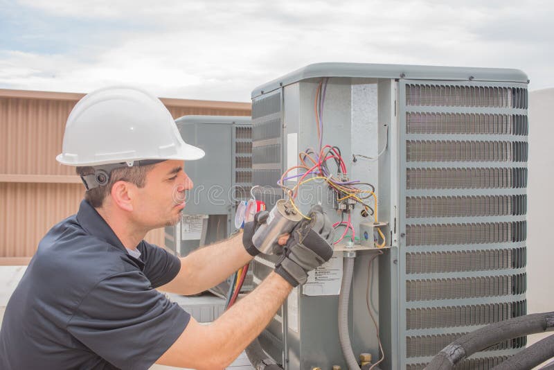 HVAC technician working on a capacitor part for condensing unit. HVAC technician working on a capacitor part for condensing unit.