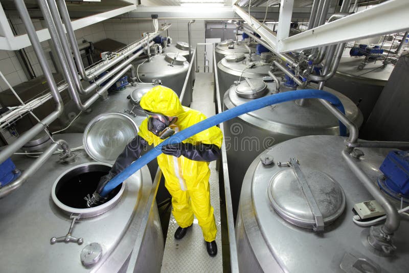 técnico que enche o grande tanque de prata na fábrica foto de stock técnico que enche o grande tanque de prata na fábrica foto de stock