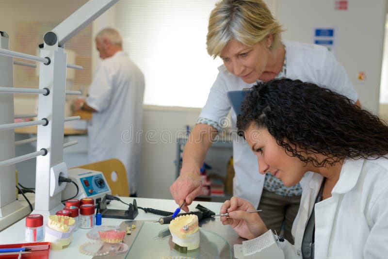 Técnico y aprendiz pulido implante dental imagen de archivo libre de regalías