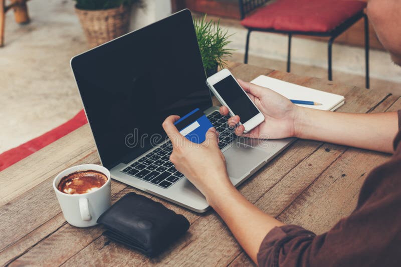 Téléphone de participation d'homme d'affaires et carte de crédit de paiement avec l'ordinateur portable o images libres de droits Téléphone de participation d'homme d'affaires et carte de crédit de paiement avec l'ordinateur portable o images libres de droits